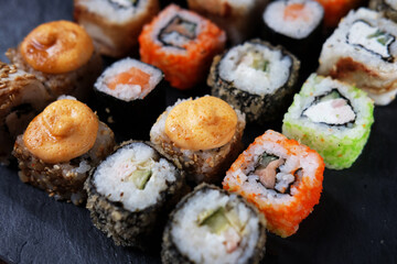 Large sushi set on black. An assortment of various maki, nigiri and rolls