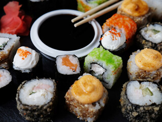 Set of sushi and maki on stone table.