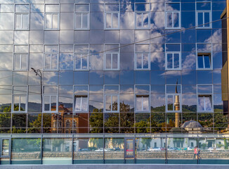 The historic cityscape reflected in the glass cover modern building . The 15th century Emperor's Mosque on the opposite bank of the Milyacka River. Sarajevo, Bosnia and Herzegovina