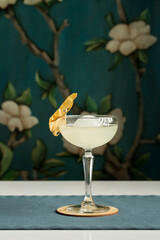 margarita glass cocktail with ice ball and dried pineapple on the table at restaurant