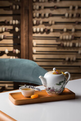 porcelain Teapot and a cup of green tea on wooden board on the table