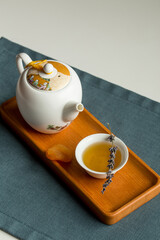 porcelain Teapot and a cup of green tea on wooden board on the table