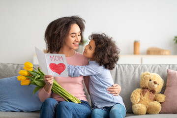 Black girl greeting mom with tulips and card