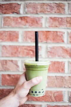 Hand Holding A Green Matcha Boba Bubble Tea 