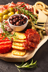 Charcuterie board with spanish jamon, pork sausage with pepper, fuet, cheese and berries