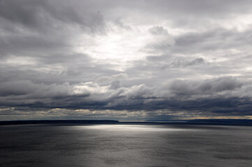 Obraz premium View of the Rybinsk reservoir. Cloudy summer day. Large clouds over the water. Rybinsk city, Russia
