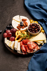 Charcuterie board with spanish jamon, pork sausage with pepper, fuet, cheese and black olives