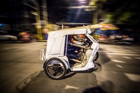 a speeding tricycle in the streets of Metro Manila. The tricycle is a common means of public transport in the Philippines.