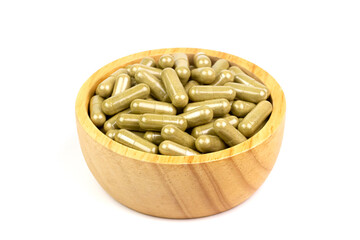 Moringa capsule in wooden bowl isolated on white background. Moringa is herb for health care.