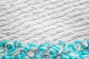 Knitted background with white and aquamarine threads.