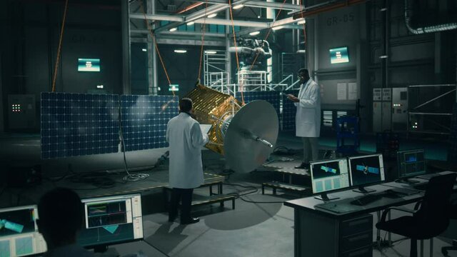 Team of Engineers Working on Satellite Construction. Aerospace Agency Spaceship Manufacturing Factory: Diverse Group of Multi-Ethnic Scientists Developing Spacecraft for International Space Program.