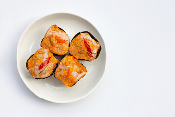 Thai streamed fish curry in banana leaves on white.
