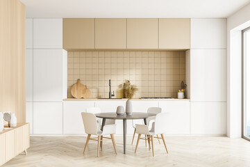 Modern kitchen interior, dining area with panoramic windows. Furnished by table and chairs for...