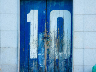 white painted number on old weathered blue door