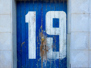 white painted number on old weathered blue door