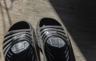 old, worn black sneakers on the floor