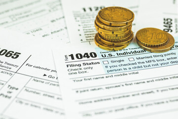 US individual income 1040 tax form babckground with stack of coins