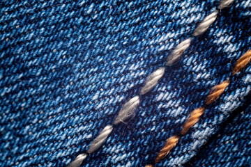 Background on the theme of denim clothing. Denim fabric with elements of seams.