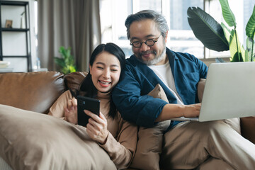 Female showing smartphone to husband in living room at home