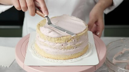 pastry chef making cake by use spatula to scrape the whipped cream. 