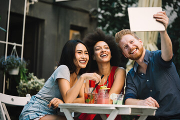 Group of diverse friends talking and having fun at cafe outdoor