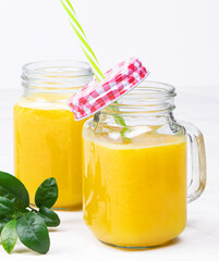 Orange juice and green leaves on a white background.A glass of orange juice Healthy food. Vegan food. Vertical orientation