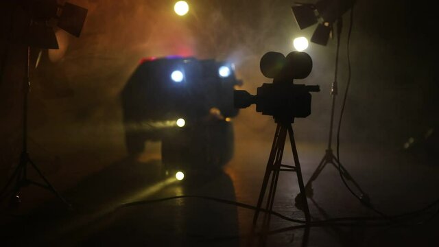 Action movie concept. Police cars and miniature movie set on dark toned background with fog. Police car chasing a car at night. Scene of crime accident. Selective focus