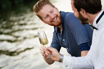 Portrait of a handsome men, friends holding champagne outdoor