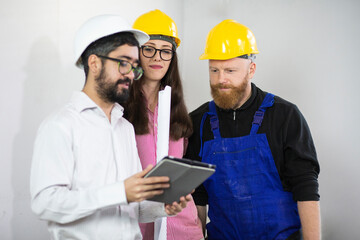 Engineers and construction worker in hardhats