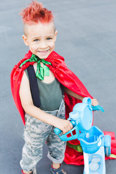 Kid superhero in a red cloak.