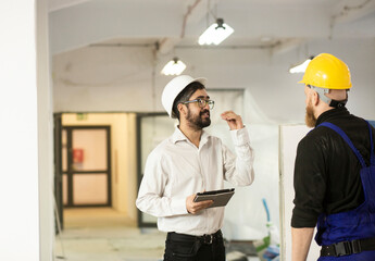 Engineer talking with construction worker