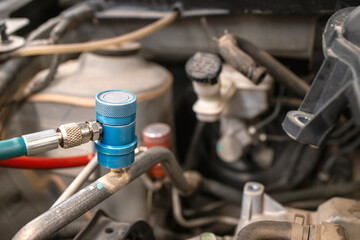 servicing car air conditioner in repair workshop with soft-focus and over light in the background
