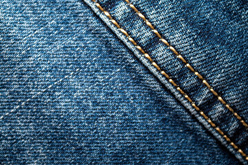 Background on the theme of denim clothing. Denim fabric with elements of seams.