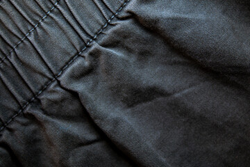 Naklejka premium Black denim with stitching details. Background on the theme of denim clothing.