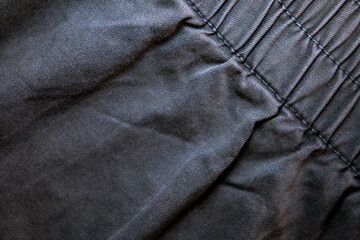 Naklejka premium Black denim with stitching details. Background on the theme of denim clothing.