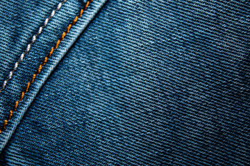 Background on the theme of denim clothing. Denim fabric with elements of seams.