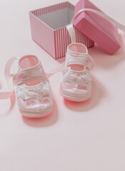 It’s a girl announcement. Baby girl pink shoes on pink color background. Baby shower, christening concept.