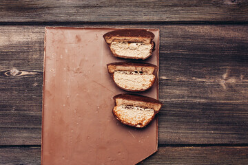 milk chocolate and cake with sweet icing on wooden table top view