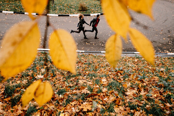 couple run away together through autumn leafs