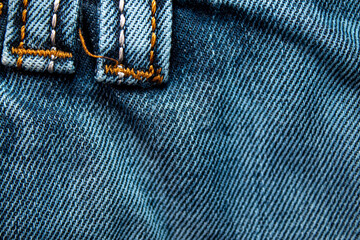 Background on the theme of denim clothing. Denim fabric with elements of seams.