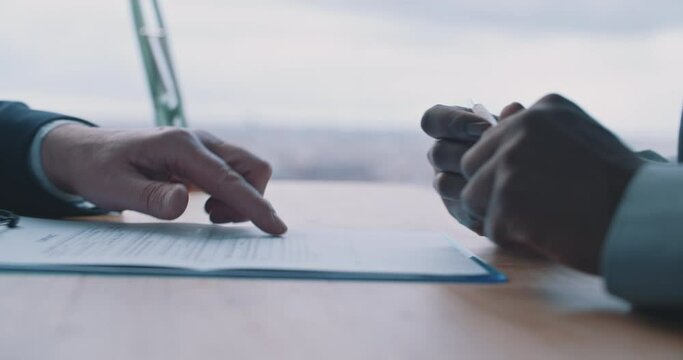 Close up of male hands holding pen and showing how to fill in form