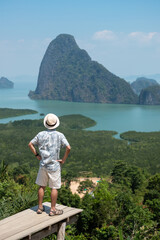Fototapeta na wymiar Happy traveler man enjoy Phang Nga bay view point, alone Tourist standing and relaxing at Samet Nang She, near Phuket in Southern Thailand. Southeast Asia travel, trip and summer vacation concept