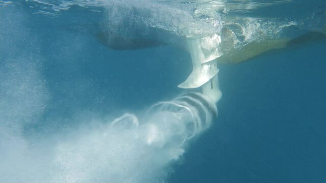 slowmotion close up shot of boat propeller starts with nice air bubbles from the engine during sunny day
