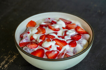 Red strawberry and white yogurt brulee. Fruit dessert on breakfast with wedges of perfectly ripe in season strawberry