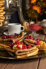 Obraz na płótnie Canvas Still life with traditional Ukrainian and Russian pancakes for the Maslenitsa holiday with butter and berries on a black tray
