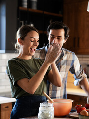 Husband and wife in kitchen. Young couple preparing delicious food at home.