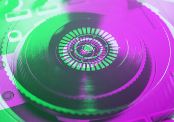 Professional dj cd player turntable.Disc jockey audio equipment in green and magenta neon lights in nightclub.Digital turn table on concert stage