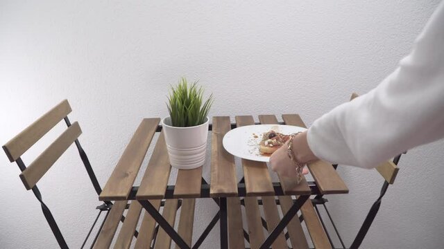 Person serving a fresh delicious bacon and egg sandwich on balcony table