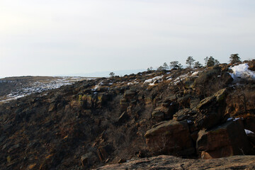 Scenic High Angle View of Rocky Cliff Mountain Peak and Snowy Valley under Winter Blue White Sky