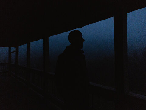 Man in hat standing on the terrace in the night